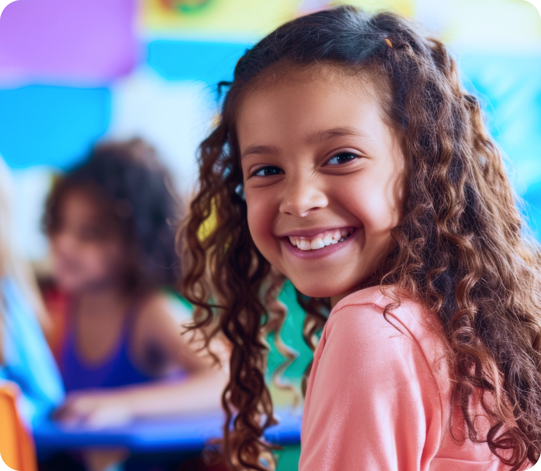 Menina sorrindo em sala de aula do Espaço Feliz